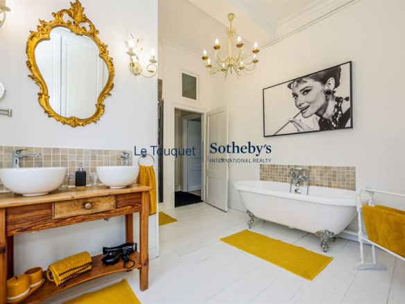Elegant bathroom with bathtub, double sink and refined decor.
