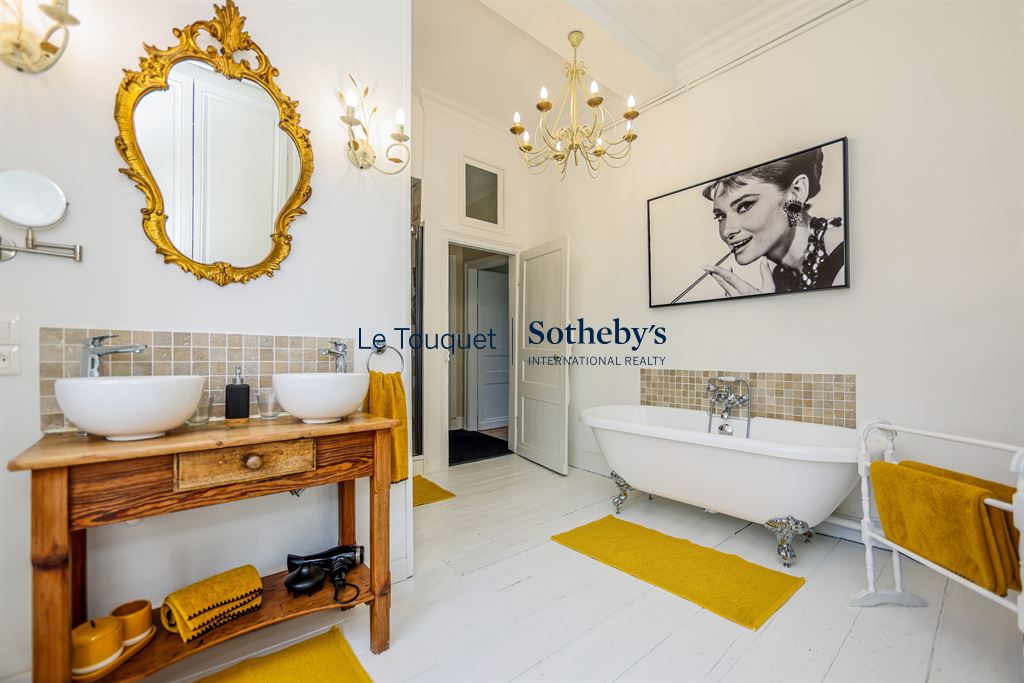 Elegant bathroom with bathtub, double sink and refined decor.