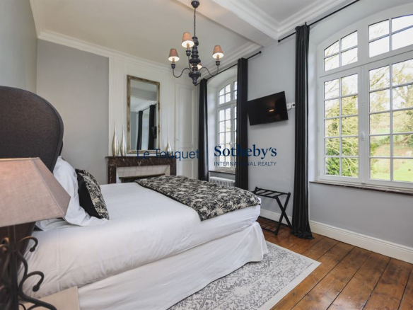 A bedroom in an 18th-century manor house with refined decor and natural light.