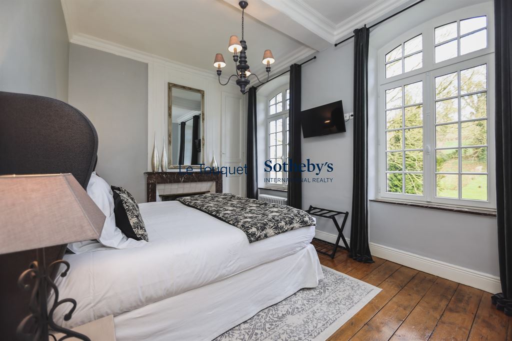 A bedroom in an 18th-century manor house with refined decor and natural light.