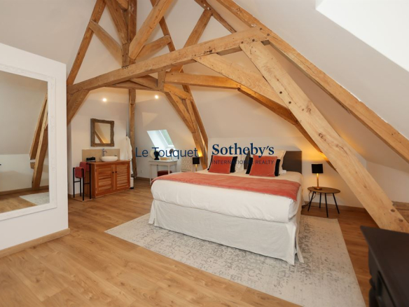 Bedroom in an 18th-century manor house with exposed beams and modern furniture.