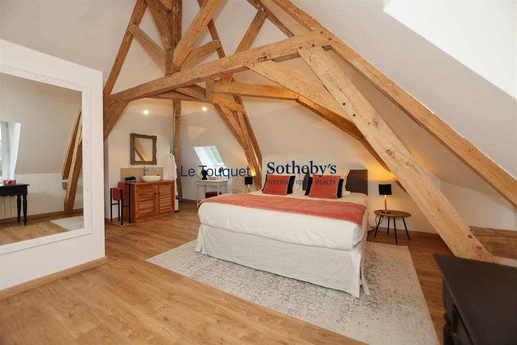 Bedroom in an 18th-century manor house with exposed beams and modern furniture.