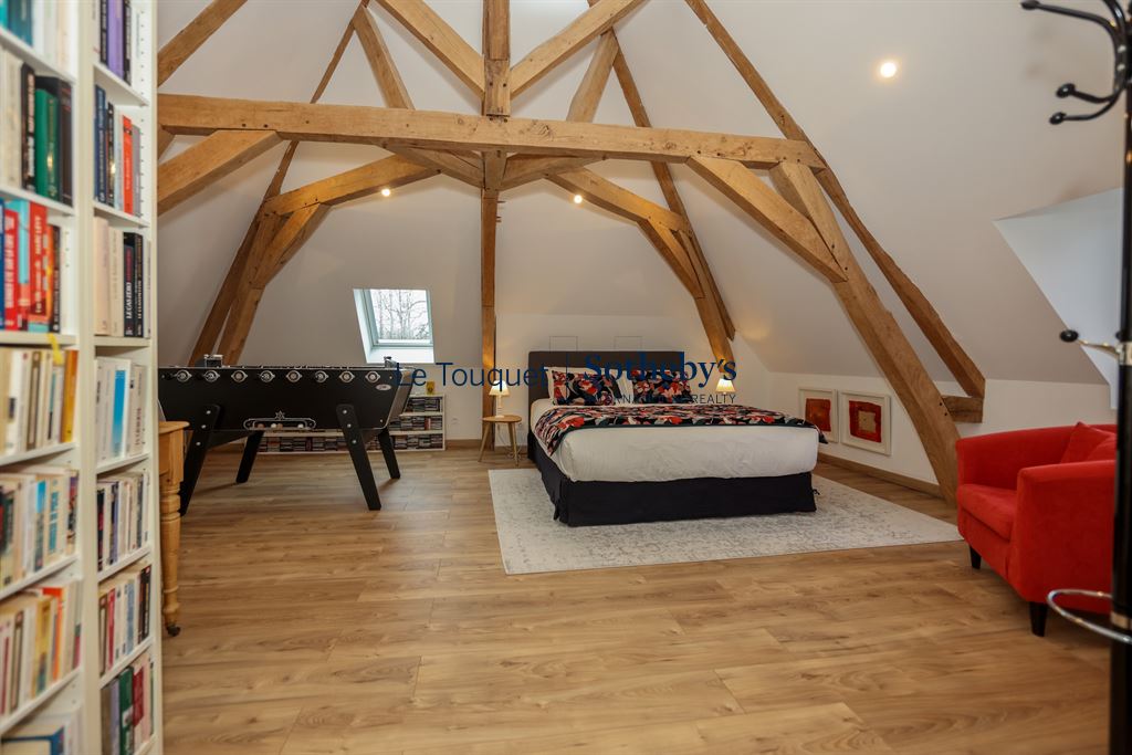 Spacious room with exposed beams, double bed and foosball table.
