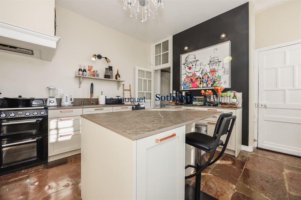 Modern and bright kitchen in a manor house with a central island and contemporary equipment.