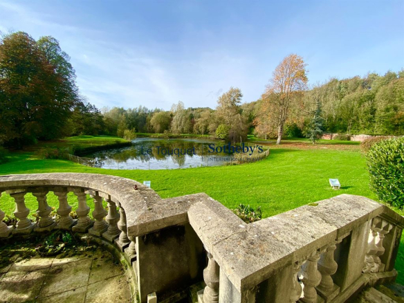 Vue d'un étang et d'un parc verdoyant entourant un château du XVIIIème siècle à Aire-sur-la-Lys.