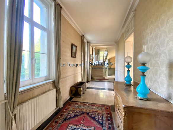 Intérieur d'un château du XVIIIème siècle avec un couloir lumineux et des décorations anciennes.
