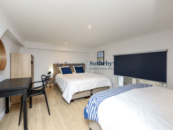 Chambre d'un duplex contemporain avec deux lits et un bureau, rénové en 2023 au Touquet-Paris-Plage.