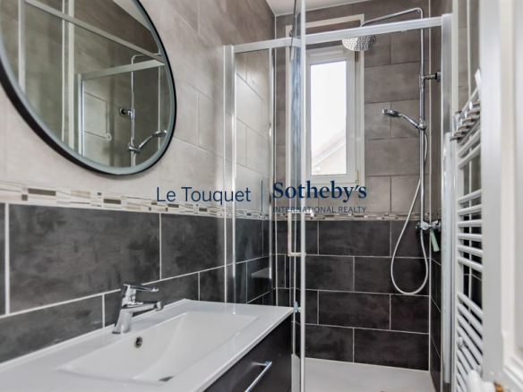 Modern bathroom with shower and sink in a renovated apartment in Le Touquet-Paris-Plage.