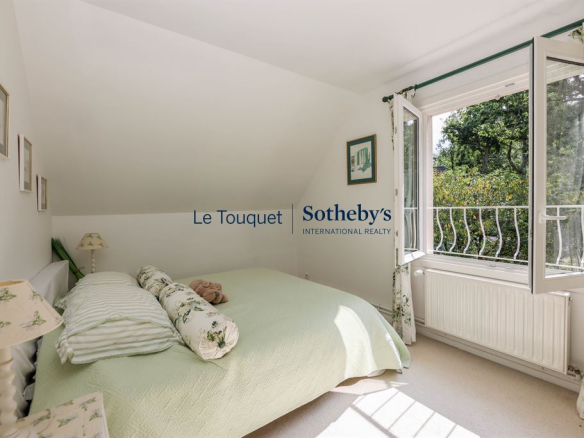 Bright room with double bed and windows opening onto the garden.