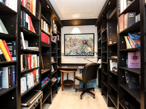 Bibliothèque avec étagères remplies de livres et un bureau dans un penthouse au Touquet-Paris-Plage.