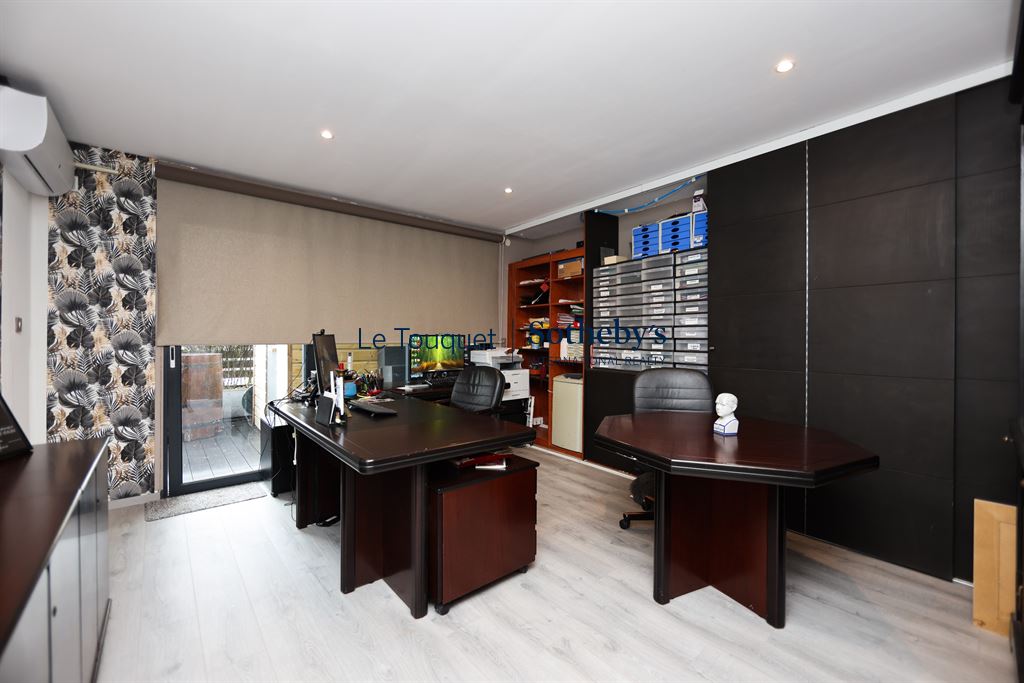 Bureau moderne dans un duplex au Touquet Bureau moderne avec deux grands bureaux et rangements, éclairage naturel, et accès à un espace extérieur.