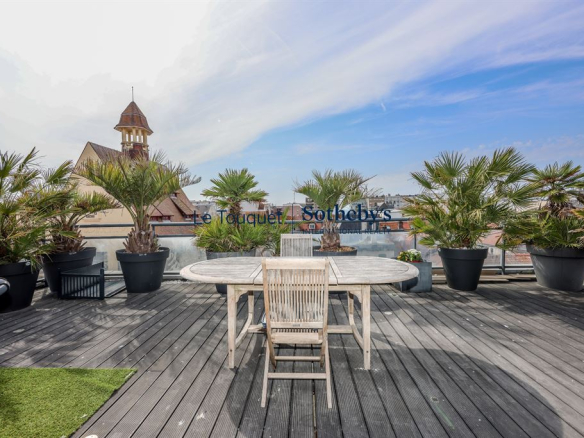 Terrasse sur le toit d'un penthouse avec vue sur Le Touquet, entourée de plantes en pot.
