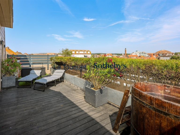 Terrasse en bois avec chaises longues et vue sur le Touquet-Paris-Plage.