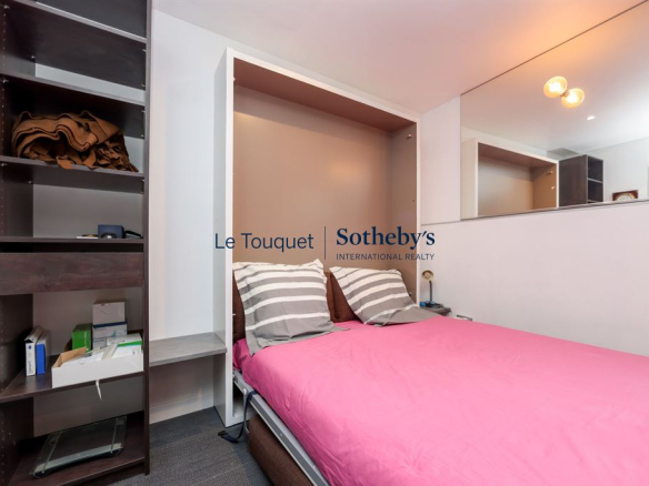 Chambre avec lit double et rangement dans un duplex au Touquet-Paris-Plage.