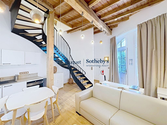 Intérieur d'un hôtel particulier du XVIIIe siècle avec escalier en colimaçon et salon lumineux.