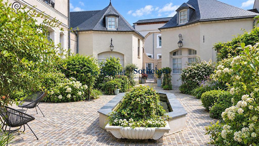 Cour intérieure d’un hôtel particulier à Montreuil-sur-Mer Cour intérieure d'un hôtel particulier du XVIIIe siècle à Montreuil-sur-Mer, avec des fleurs et des sièges.