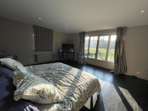 Chambre spacieuse avec lit et accès à l'extérieur, lumière naturelle abondante.